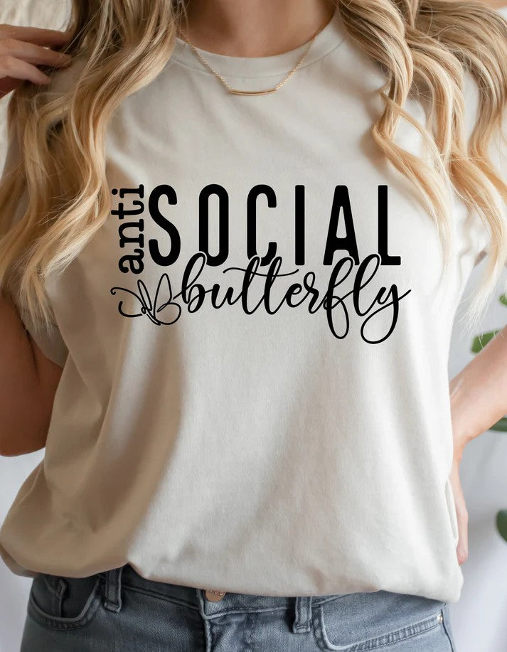 Model wearing light beige Gildan Softstyle unisex t-shirt with “Anti-Social Butterfly” text and butterfly accent graphic – Oaklieten woman-owned brand