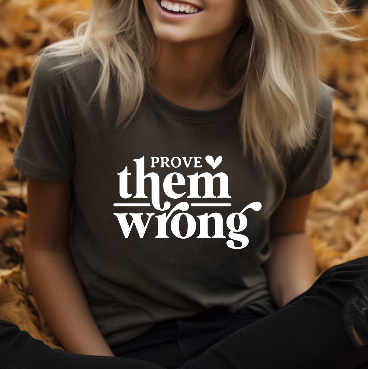 Prove Them Wrong motivational graphic t-shirt in dark gray with bold white lettering, styled for casual everyday wear.